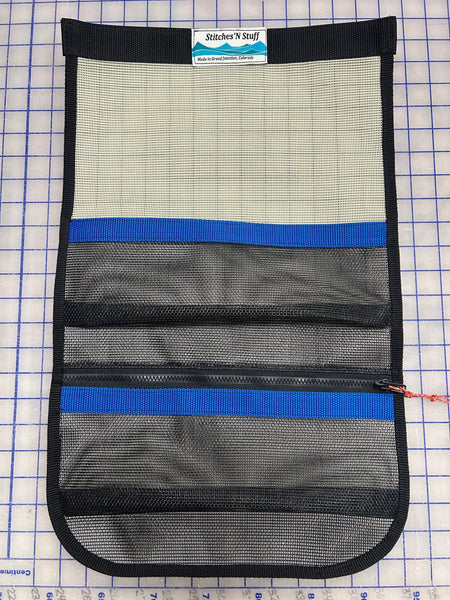 A tan and black mesh storage cubby with blue webbing for use in truck campers