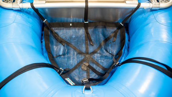 Black mesh cargo floor displayed in blue raft with straps attached to raft and raft frame. 
