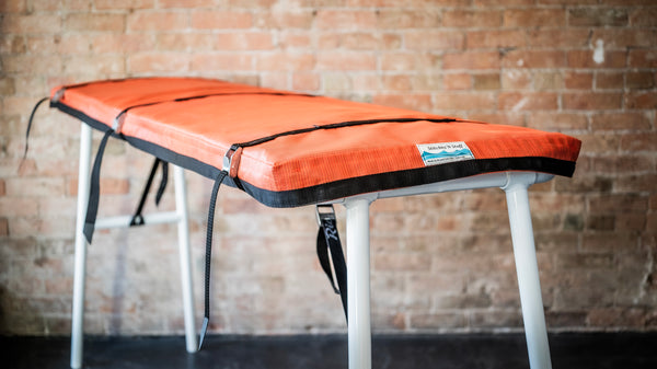 Padded cover for raft attached to river table.