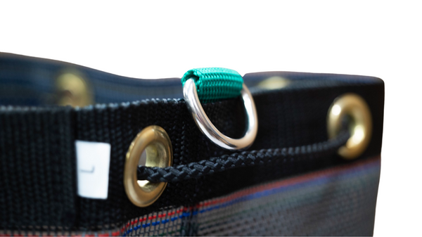 Close up of mesh round bottom bag showing stainless steel D-ring and cinch closure. 