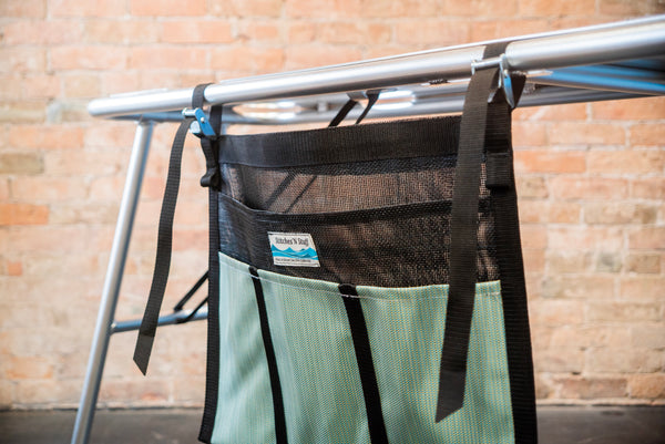A green and black mesh dish dryer attached to a raft table. 