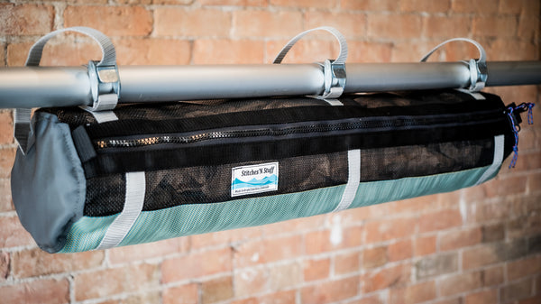 Green and black mesh raft frame storage bag with full length zipper and three cam buckle attachments for securing to raft frame. 