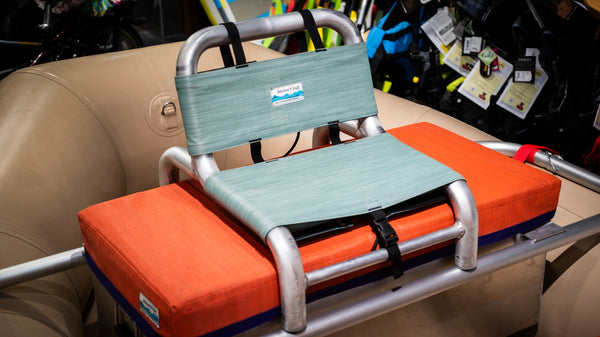 Green cover for raft captains seat on a raft frame and tan raft. 
